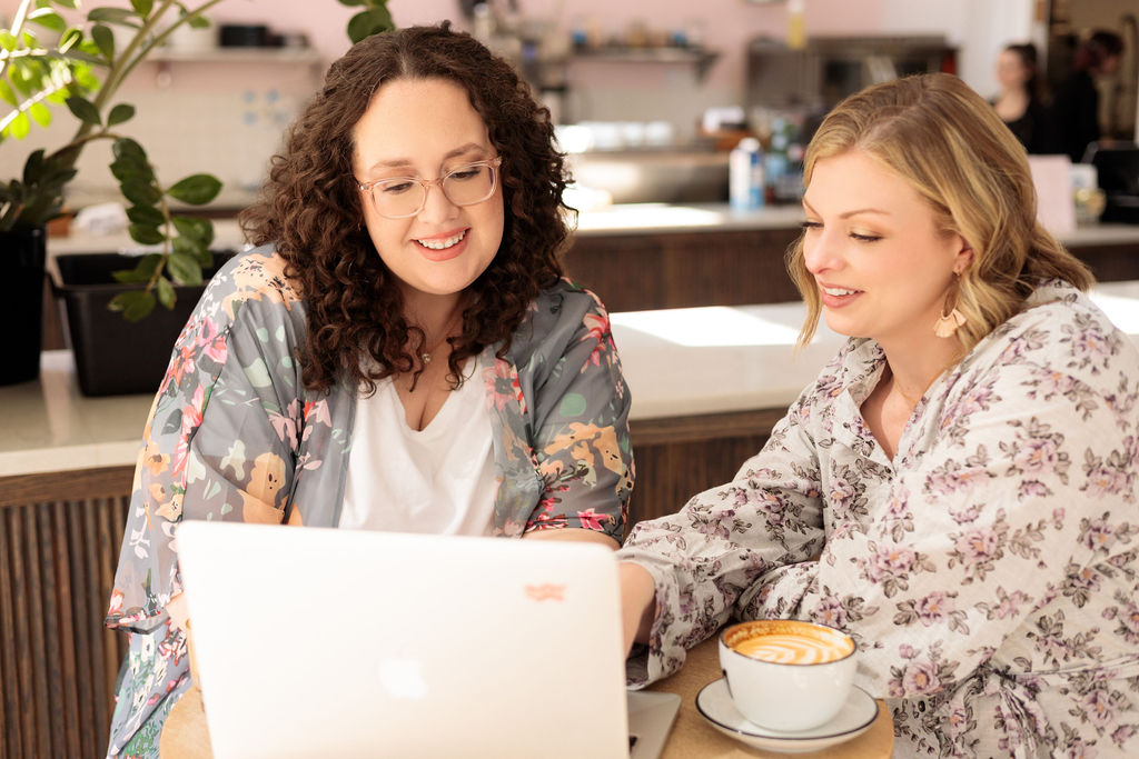 Co founders Maureen and Nicole looking at computer screen strategizing