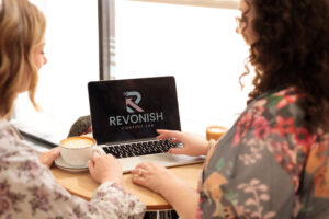 Maureen and Nicole behind looking at laptop on Revonish